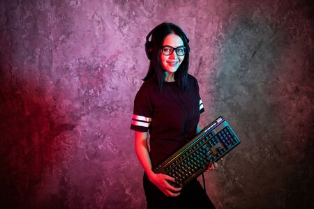 Funny nerd girl wearing glasses carrying computer keyboardの写真素材