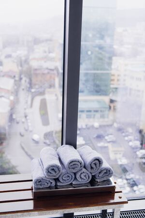 Stack of rolled towels in hotel at gym with city viewの写真素材
