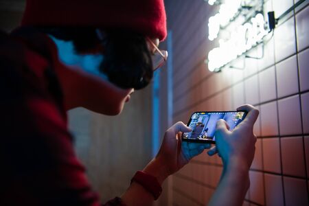 MOSCOW, RUSSIA - December 6, 2019: female playing tablet or smartphone at home. Girl playing PUBG Online game on mobile phoneのeditorial素材