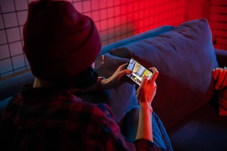 MOSCOW, RUSSIA - December 6, 2019: Girl playing PUBG FPS game on smartphone. Teenager into mobile...