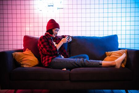 Close up portrait of pretty teenager girl playing online game in telephone wearing casual jeans...
