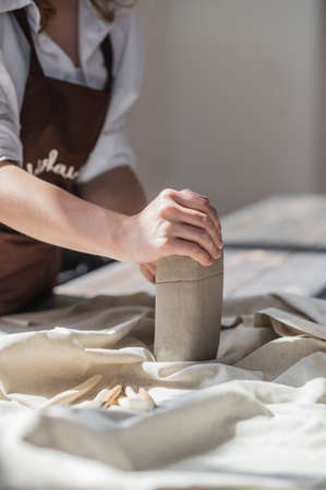 Professional female potter shaping and carving parts pottery workshop, studio. Crafting, artwork and handmade concept.の写真素材
