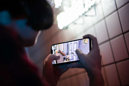 MOSCOW, RUSSIA - December 6, 2019: female playing tablet or smartphone at home. Girl playing PUBG...