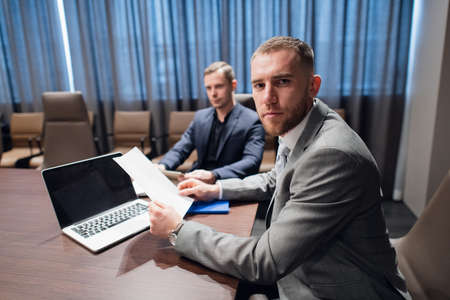 Female worker showing papers to her serious boss in the meeting room