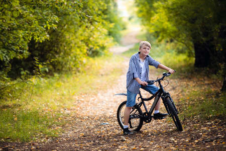 Boy rides the bike in the autumn forestの写真素材