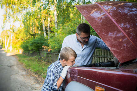 The father and son checking the car engine.の写真素材