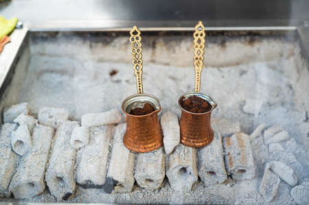 A turkish coffee pot on some wood burning with coffee inside. Street coffee in Istanbul, Turkey.の写真素材