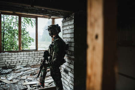 A thoughtful soldier, resting from a military operation while it is raining outside.の写真素材
