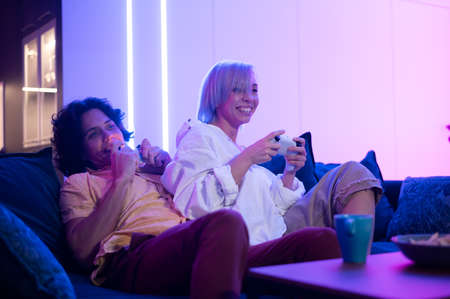 Portrait of emotional young couple playing video game at home.の写真素材