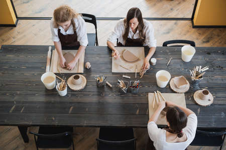 Women working In pottery studio, smiling and talking. Ceramic workshop, pottery master class.の写真素材