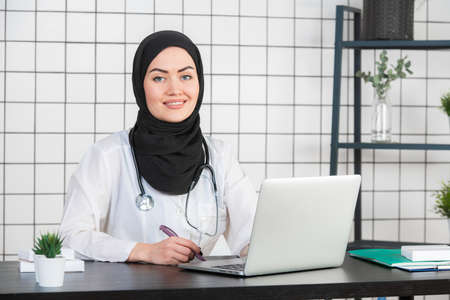 Muslim Female Doctor at her desk. White Backgroundの写真素材