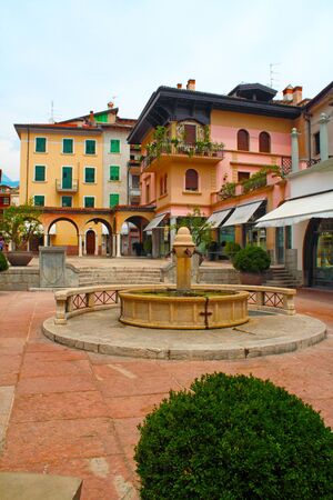 Riva del Garda, Italy, historic street with fountain and housesの写真素材