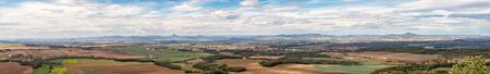 rural landscape panorama with villages, fields and mountains in background, blue sky with white clouds, view from Rip mountain, Ceske stredohori, Czech republicの写真素材