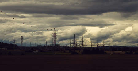 landscape panorama with dramatic overcast sky, high voltage pylonsの写真素材