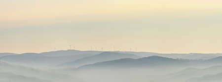 Wind power stations - wind turbines on the horizon, in the mountains, skyの写真素材