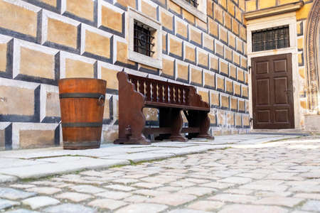 an old brown wooden barrel and bench in the historic courtyard with stone paving, castle Cesky Krumlov, Czech republicのeditorial素材