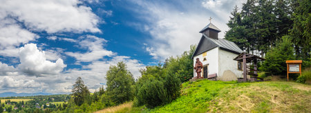Chapel of the Assumption of the Virgin Mary with a statue of a pilgrim at Adam hill near Ceske Petrovice, Czech republicのeditorial素材