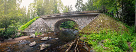 Stone bridge over the Divoka Orlice River in the Zemska brana Nature Reserve, Earth Gate, Czech...