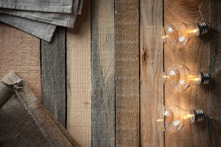 Top view image with bulbligt garland and canvas bag on raw rustic background.の写真素材