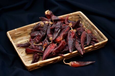 Dried red peppers are lying in a heap, glitering with different shades of redの写真素材