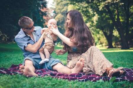 A happy family with child resting in parkの写真素材