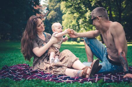 A happy family with child resting in parkの写真素材