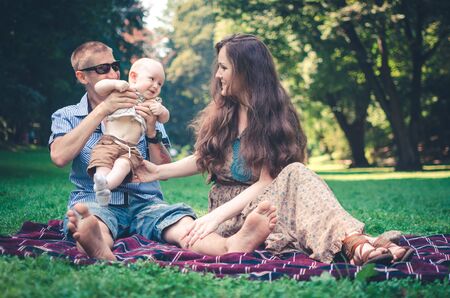 A happy family with child resting in parkの写真素材