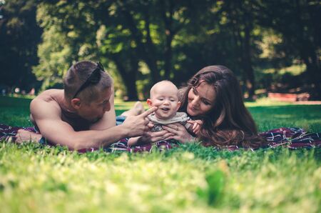 A happy family with child resting in parkの写真素材