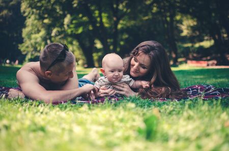 A happy family with child resting in parkの写真素材