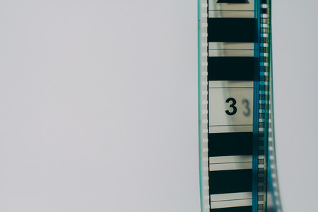 analogue film strip in right corner with copyspace on white backgroundの写真素材