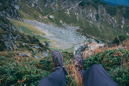 Man legs, sitting on edge of gorge. Point of view, focus on legs, Carpathian mountains, Marmaroshの写真素材