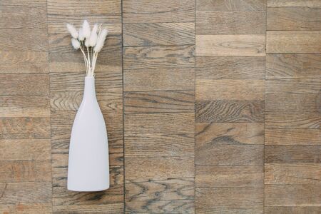 Bouquet of dried flowers in white ceramic vase on vintage wooden planks, top view horizontalの写真素材