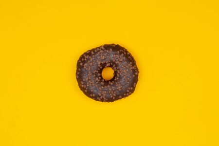Sweet chocolate donut on yellow background. Dessert foodの写真素材