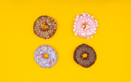 Sweet chocolate donut on yellow background. Dessert foodの写真素材