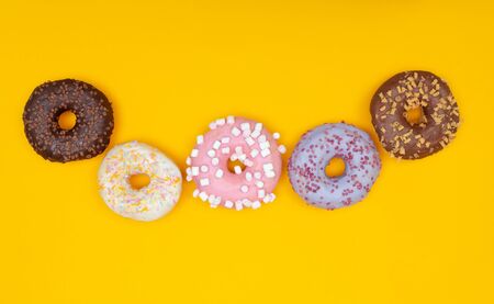 Sweet chocolate donut on yellow background. Dessert foodの写真素材