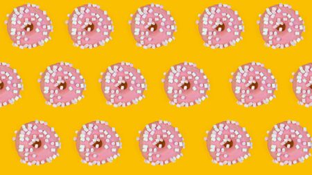 Pattern of sweet donuts on yellow background. Sweet tasty food, top view.の写真素材