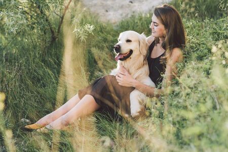 Beauty woman with her dog playing outdoors.の写真素材