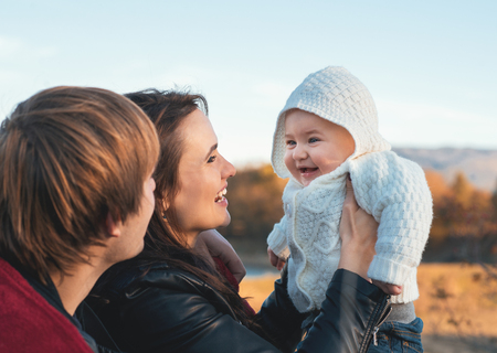Close up portrait of happy young family having fun outdoors in autumn park.の写真素材