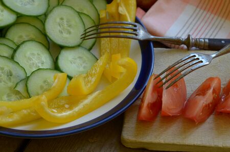 Homegrown cut tomato, pepper and cucumber on rustic tableの写真素材