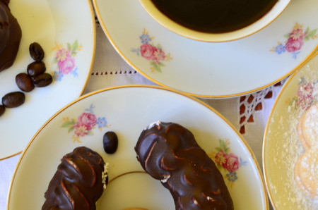 Desserts with cup of coffee, coffee beans and almonds on white tablecloth