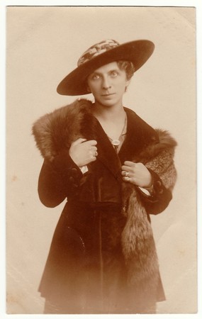 POSEN, POLAND - AUGUST 18, 1920: Vintage photo shows an elegant woman wears fur scarf and wide-...