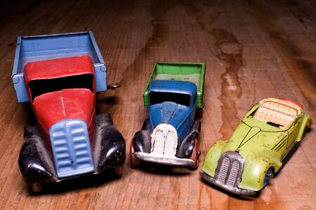 Vintage toy cars (lorry (truck) and convertible car)  on brown wooden background. Retro toys for boys. Flat design.の写真素材