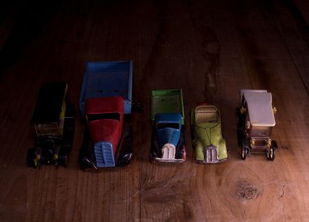 Vintage toy cars (lorry (truck) and convertible car)  on brown wooden background. Retro toys for...
