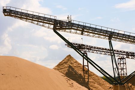 Conveyor belts and sand heaps. Construction industry. Sand quarry. Horizontal  photo.