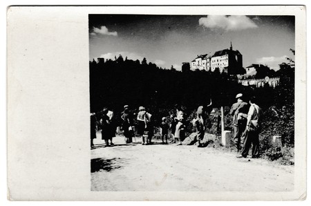 THE CZECHOSLOVAK SOCIALIST REPUBLIC - CIRCA 1950s: Retro photo shows tourists outside. The castle is on background. Vintage black & white photography.のeditorial素材