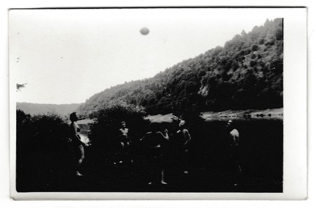 THE CZECHOSLOVAK SOCIALIST REPUBLIC - CIRCA 1950s: Retro photo shows people on the vacation. Young people play with ball. Summer holiday theme. Vintage black & white photography.のeditorial素材