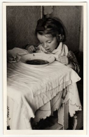 HODONIN, THE CZECHOSLOVAK REPUBLIC, CIRCA 1943: A small girl eats soup, circa 1943.のeditorial素材