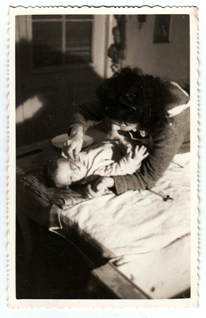 HODONIN, THE CZECHOSLOVAK REPUBLIC, CIRCA 1940: Mother feeds her baby girl, circa 1940.のeditorial素材