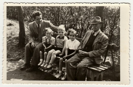 HODONIN, THE CZECHOSLOVAK REPUBLIC, CIRCA 1940: A vintage photo shows men with children. They sit on a bench, circa 1940.のeditorial素材