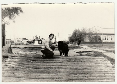 USSR - CIRCA 1970s: Vintage photo shows man strokes the dog on the street.のeditorial素材